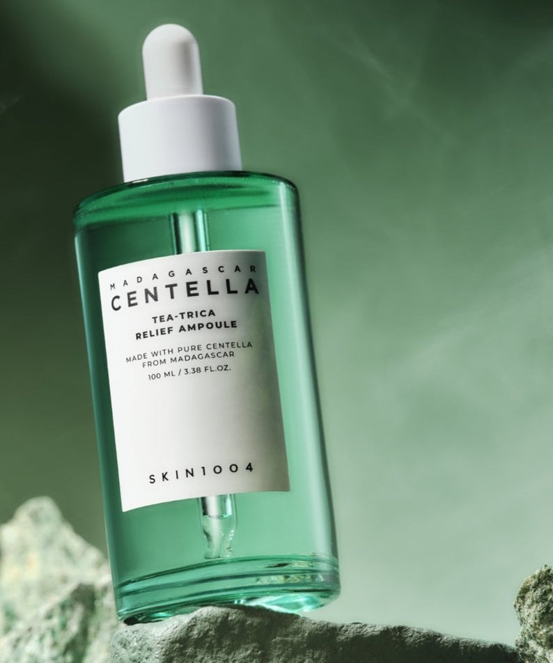 Flacon de SKIN1004 Madagascar Centella Tea-trica Relief Ampoule 100ml sur fond vert.
