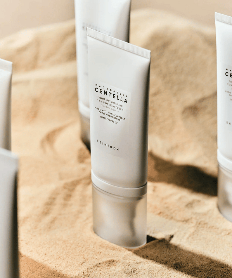 SKIN1004 Madagascar Centella Tone Brightening Tone-Up Sunscreen 50ml en tube sur sable, idéal pour protection solaire et éclat de la peau