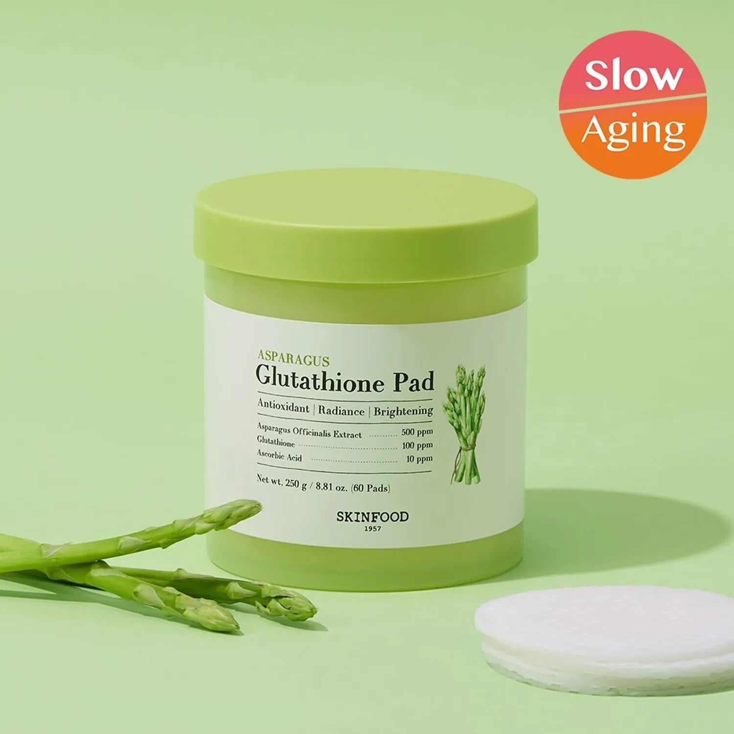 SKINFOOD Asparagus Glutathione Pad (60 Pads) de la marque SKINFOOD, sur fond vert avec gants et cœurs d’asperge.