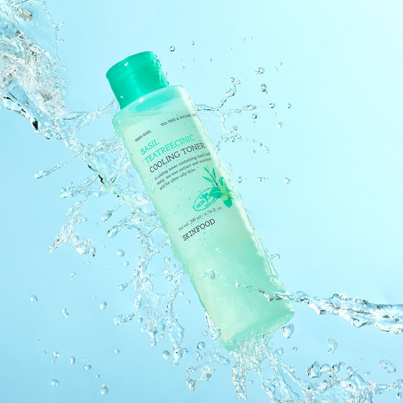 SKINFOOD Basil Tea Tree Cynic Cooling Toner 200ml, bouteille SKINFOOD sur fond bleu avec éclaboussures d’eau, visuel rafraîchissant
