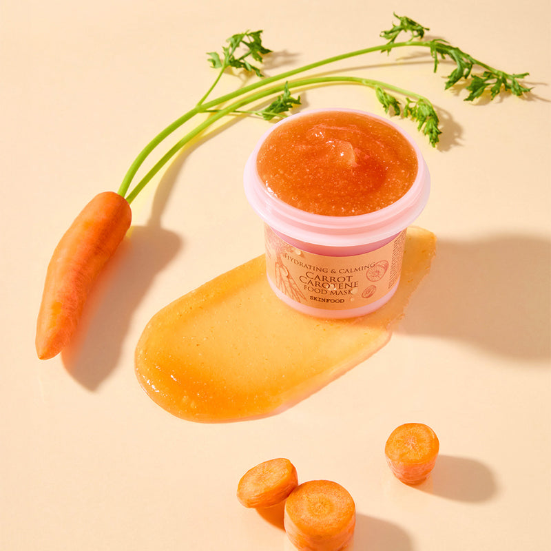 SKINFOOD [NEW ] Carrot Food Mask 120g, masque visage à la carotte sur fond beige avec carottes et pot produit.