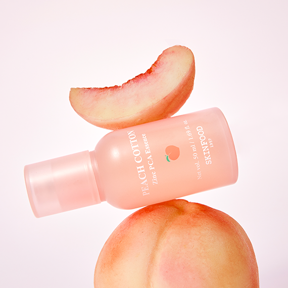 SKINFOOD Peachy Zinc PCA Essence 50ml de la marque SKINFOOD, flacon rose sur fond clair, décor pêches.