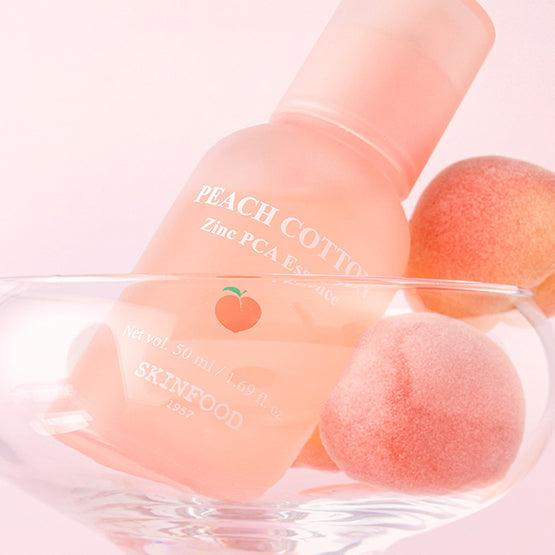 SKINFOOD Peachy Zinc PCA Essence 50ml de la marque SKINFOOD, flacon rose sur fond pastel avec fruits et coton.