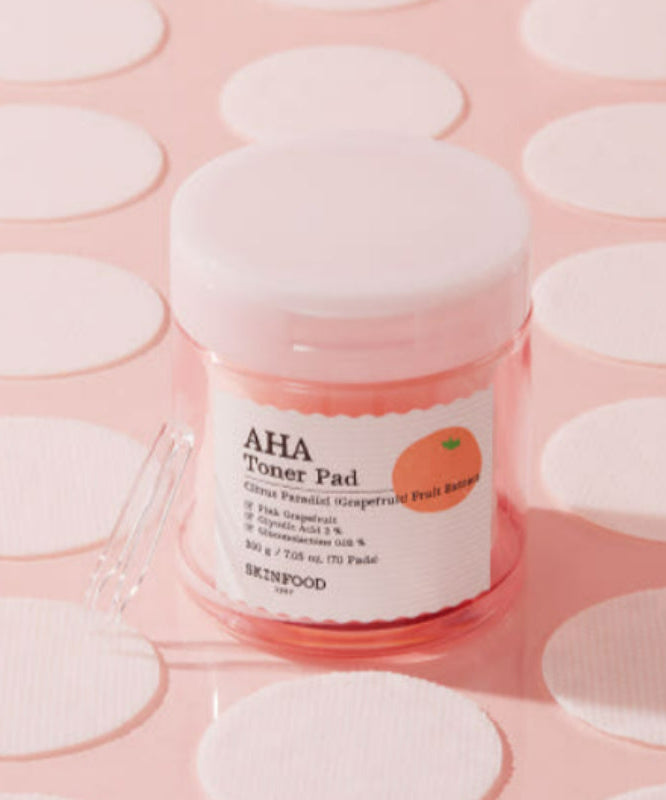 SKINFOOD Pink Grapefruit AHA Toner Pad 70 sheets, marque SKINFOOD, pack rose sur pads ronds en contexte visuel cosmétique.