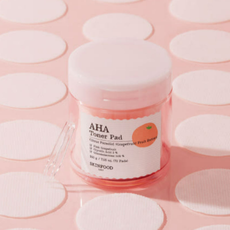 SKINFOOD Pink Grapefruit AHA Toner Pad 70 sheets, marque SKINFOOD, pack rose sur pads ronds en contexte visuel cosmétique.