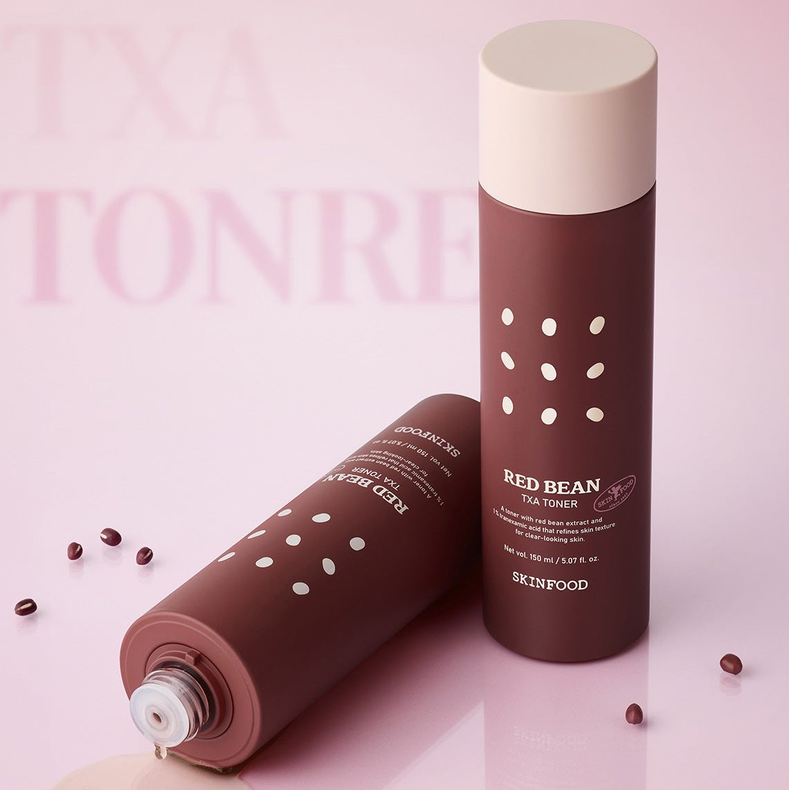 SKINFOOD Red Bean Tranexamic Acid Toner 150ml de la marque SKINFOOD, en flacon sur fond rose, éclats de haricots