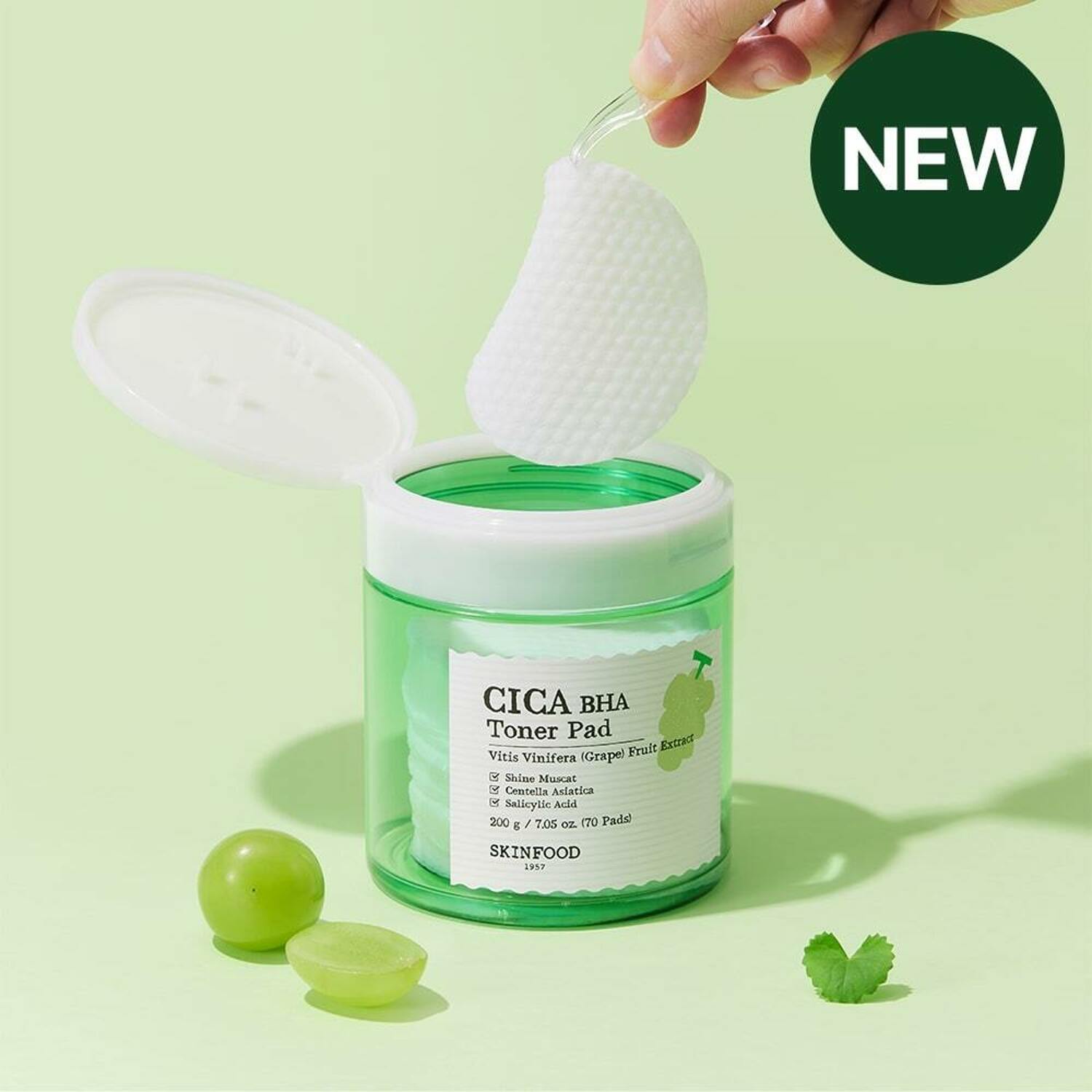 SKINFOOD Shine Muscat Cica Bach Toner Pad (70 sheets) de SKINFOOD, pad blanc sur pot vert, fond vert pastel.