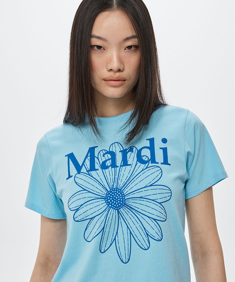 SLIM TSHIRT FLOWERMARDI_SKY BLUE Mardi Mercredi, t-shirt sky bleu slim avec fleur Mardi, modèle posant sur fond clair.