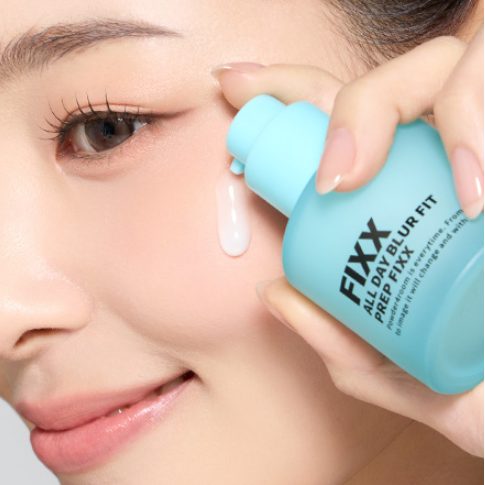 SO NATURAL All Day Blur Fit Prep Fixer 30ml, marque SO NATURAL, application sur le visage, mains tenant le flacon bleu.