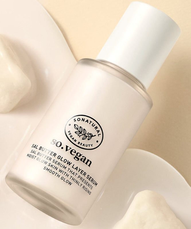 SO NATURAL Sal Butter Blending Serum 50ml, flacon crème en contexte spa minimaliste, marque SO NATURAL, mains en arrière-plan.