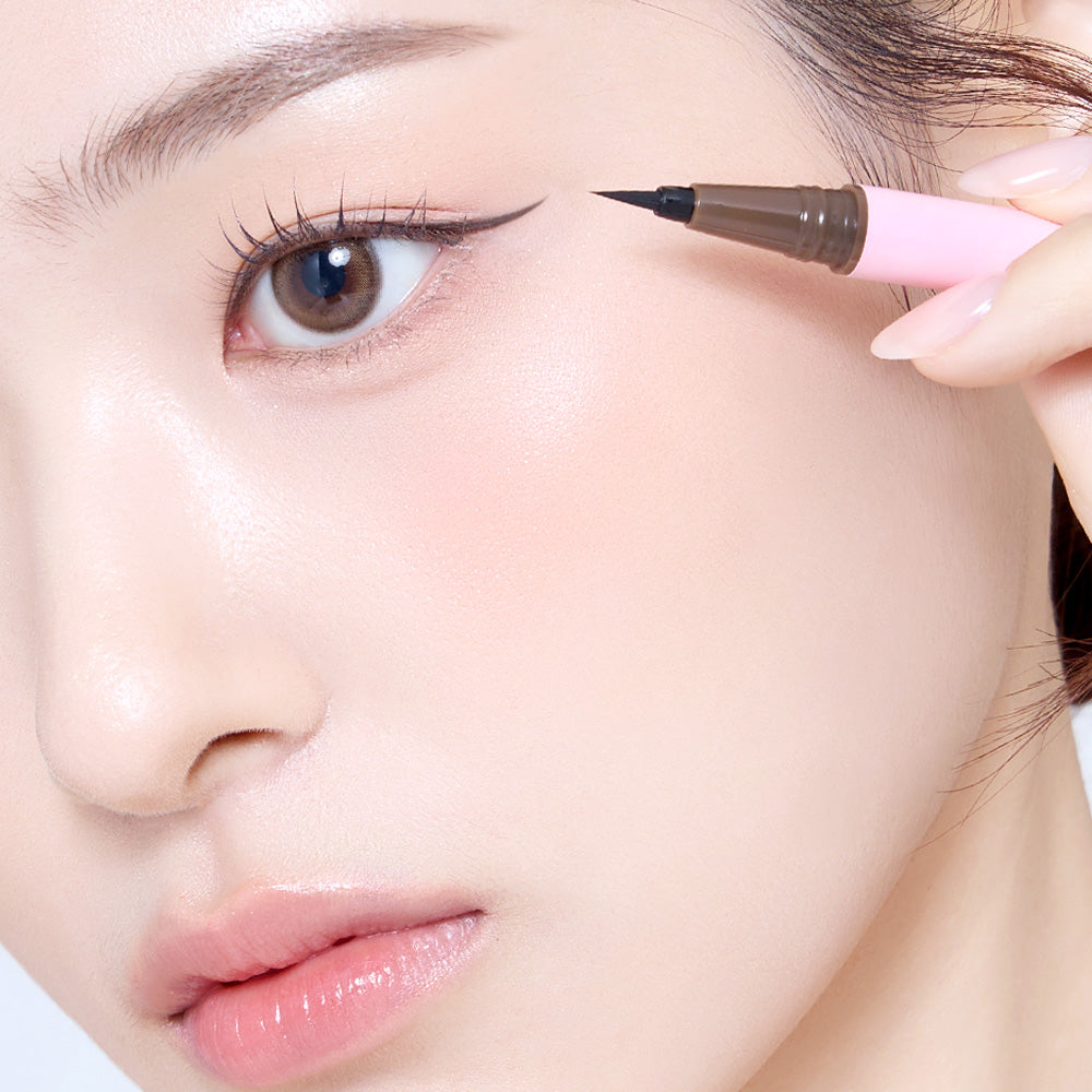 SO NATURAL Super Fix Slim Pen Eyeliner : application sur l’œil, main tenant le stylo noir, gros plan maquillage naturel.
