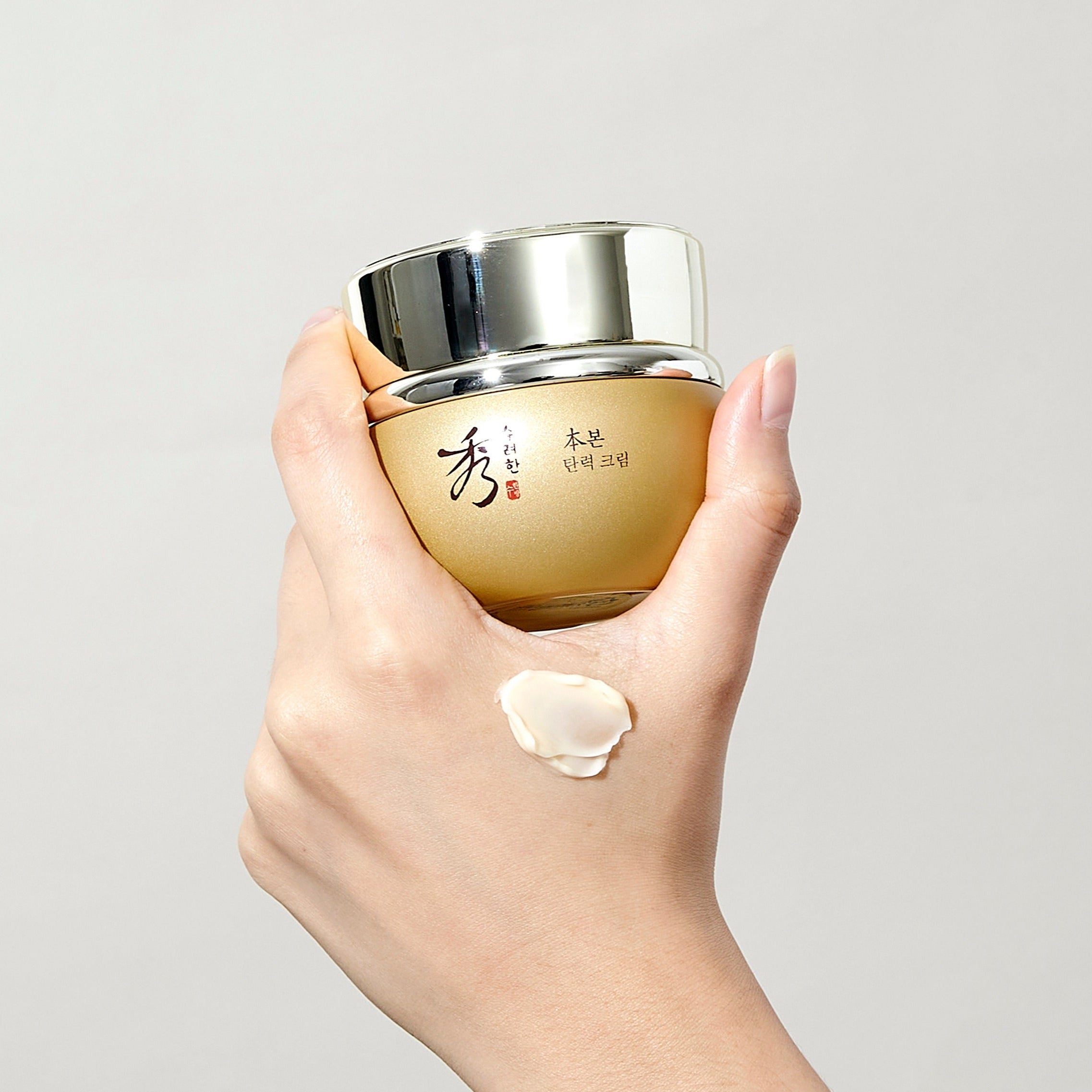 SOORYEHAN Bon Elasticity Cream 75ml : crème hydratante en pot doré, main appliquant une texture, fond clair.