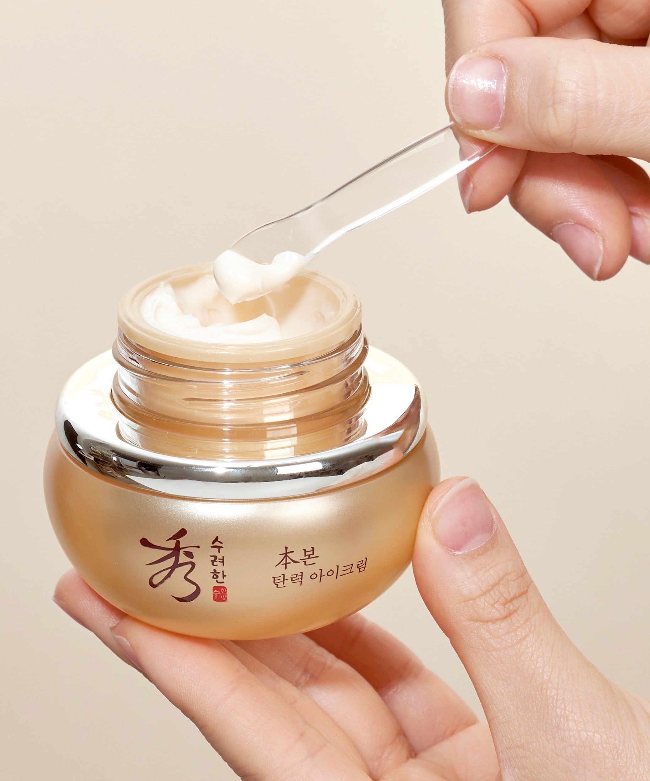 SOORYEHAN Bon Elasticity Eye Cream 25ml, main tenant le pot, crème appliquée sur l’ouverture, contexte soin beauté.