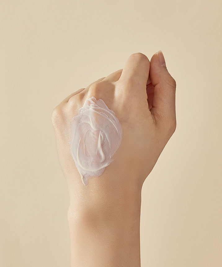 Décris l'image en français : main appliquant SOORYEHAN Hyobidam Fermented Sunscreen 60ml de la marque SOORYEHAN, texture crème.