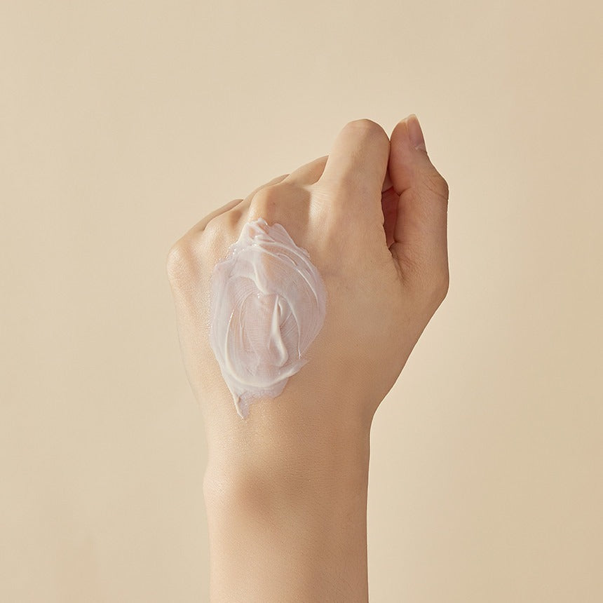 Décris l'image en français : main appliquant SOORYEHAN Hyobidam Fermented Sunscreen 60ml de la marque SOORYEHAN, texture crème.