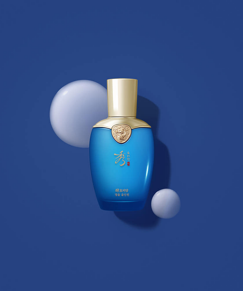 Décris l’image en français : SOORYEHAN Hyobidam Jeongyul All-in-One 100ml, flacon bleu SOORYEHAN sur fond bleu, sphères 3D.