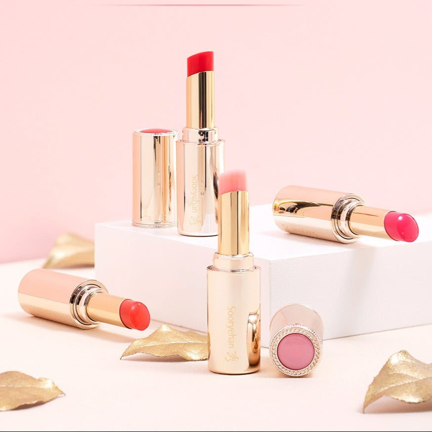 SOORYEHAN Yeon Silk Lip Balm 3.5g, marque SOORYEHAN : stick et baume sur fond rose, capsules dorées et reflets glam.