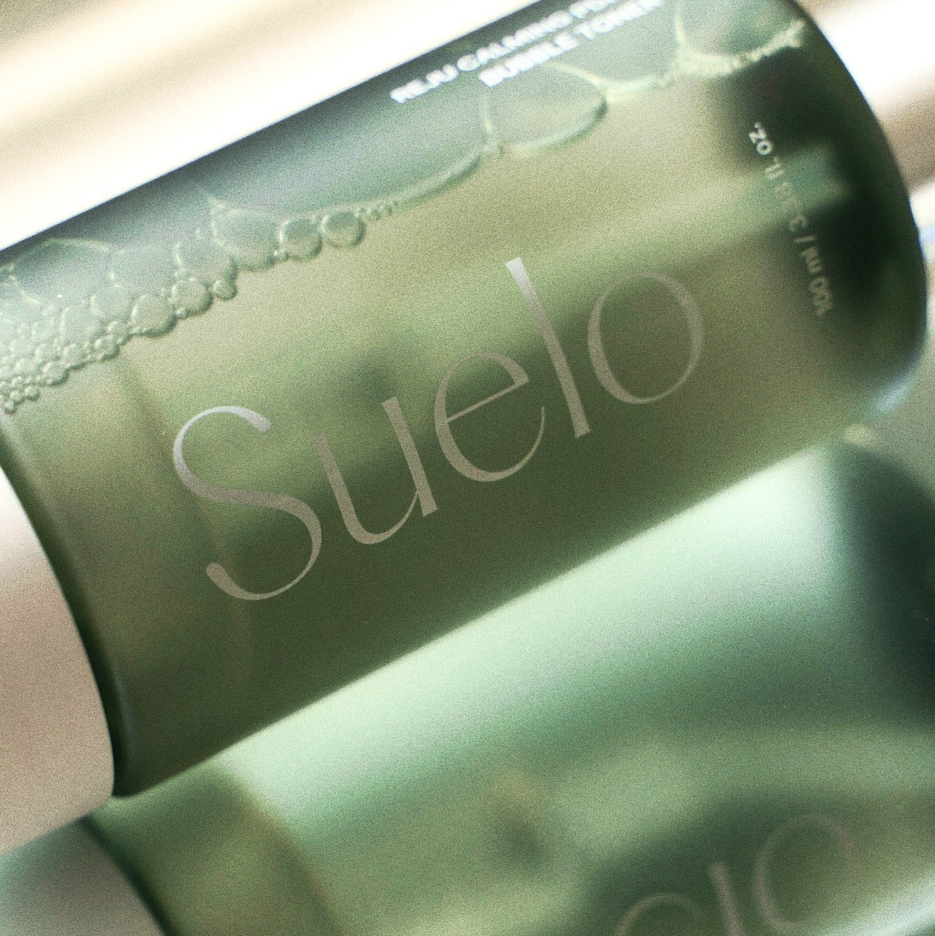 SUELO Reju Calming PDRN Bubble Toner 100ml, flacon vert en gros plan sur fond clair, bulles et PDRN visibles