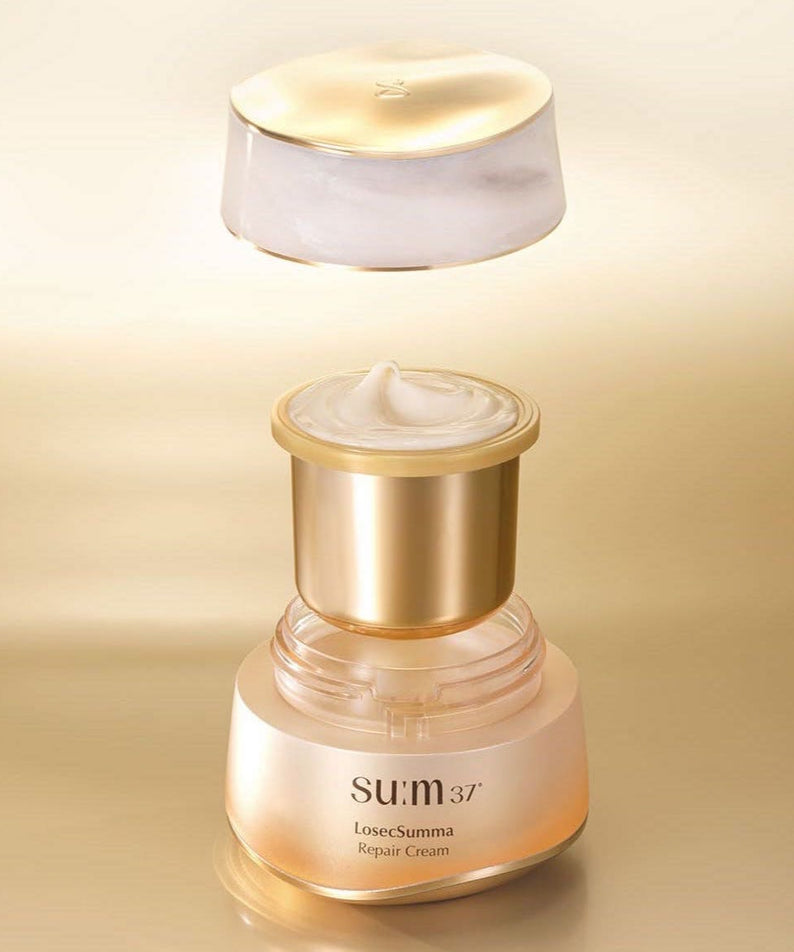 Crème SU:M37 Rosicsumma Repair Cream 50ml sur fond doré, pot ouvert avec la texture visible, produit de soin haut de gamme.