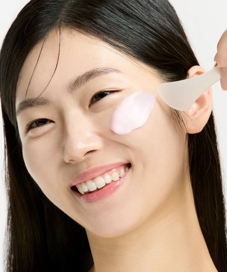 SUNGBOON EDITOR Boosting Modeling Pack Apple Peel Glow Soothing, photo soin visage pomme/peel, étendue sur peau par modèle.