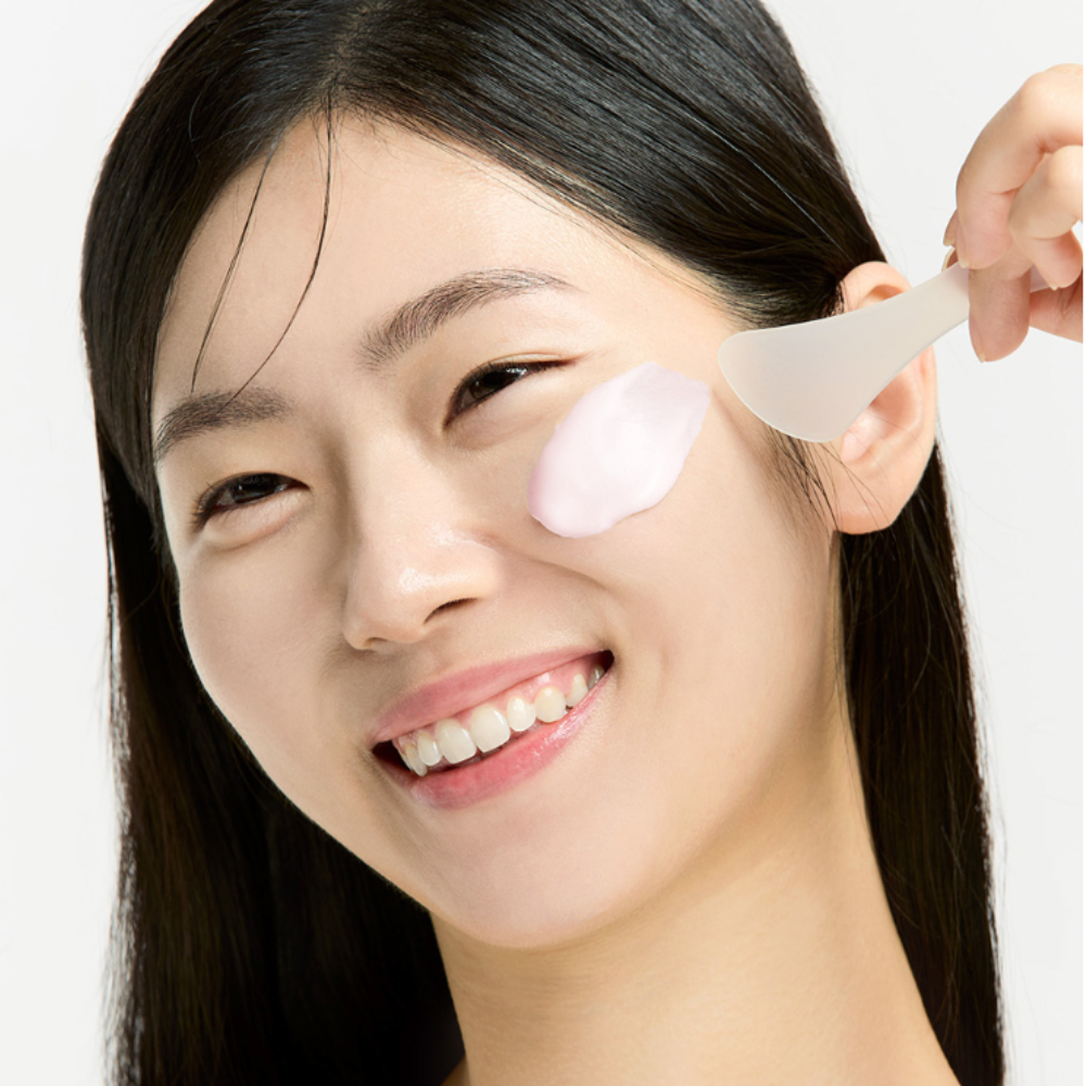 SUNGBOON EDITOR Boosting Modeling Pack Apple Peel Glow Soothing, photo soin visage pomme/peel, étendue sur peau par modèle.