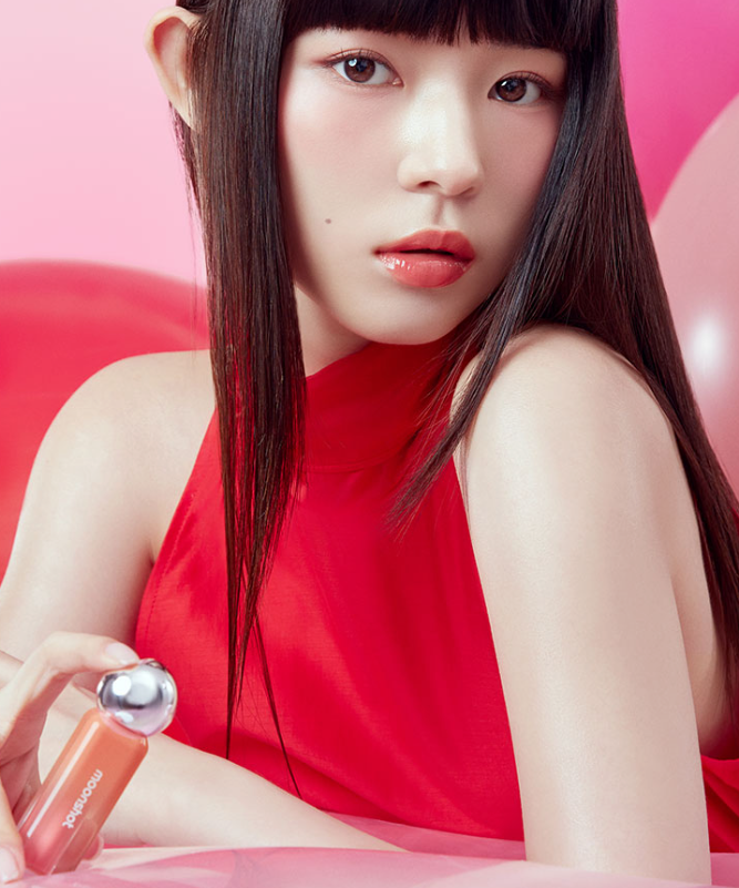 Femme élégante portant le MOONSHOT Jelly Moon Glow Tint, maquillage vibrant et moderne.