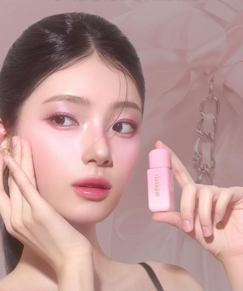 Femme tenant un flacon de DASIQUE Silky Veil Blush, maquillée délicatement, mise en avant du produit de beauté.