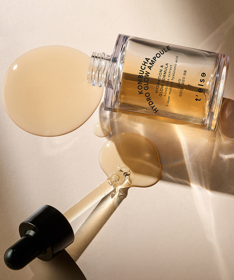 T'ELSE Kombucha Hydro Glow Ampoule 30ml en flacon avec pipette sur fond beige lumineux, cosmétique coréenne pour éclat de la peau.