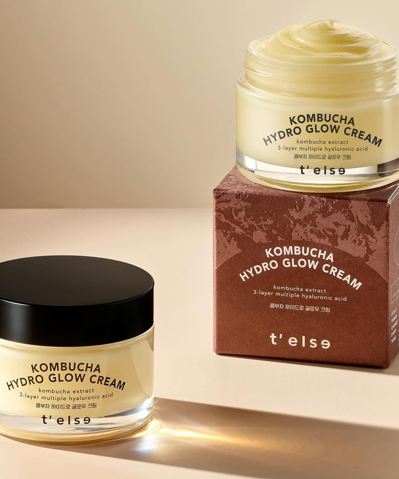 Crème T'ELSE Kombucha Hydro Glow 50ml en pot ouvert et fermé sur un emballage, éclairage doux, soin de la peau éclatant.