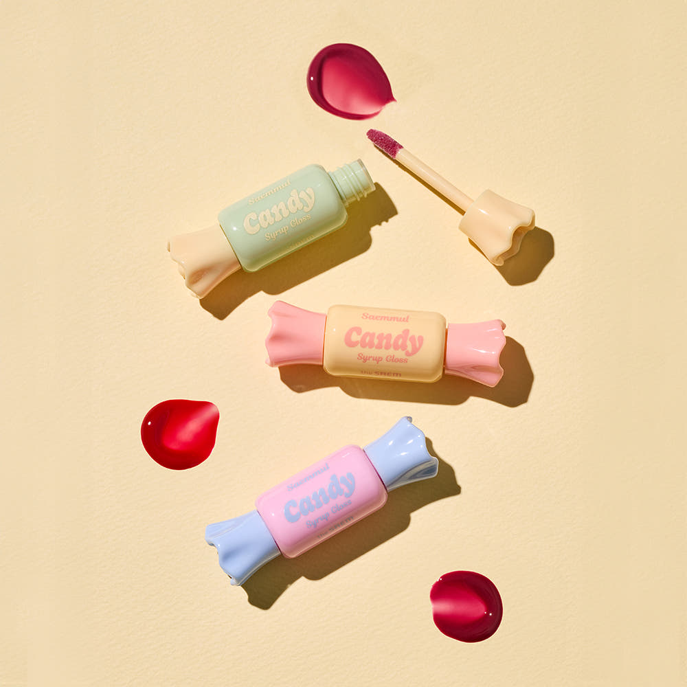 THE SAEM Saemmul Candy Syrup Gloss, pack candy pastel et applicateur rouge sur fond beige, marque THE SAEM, contexte visuel