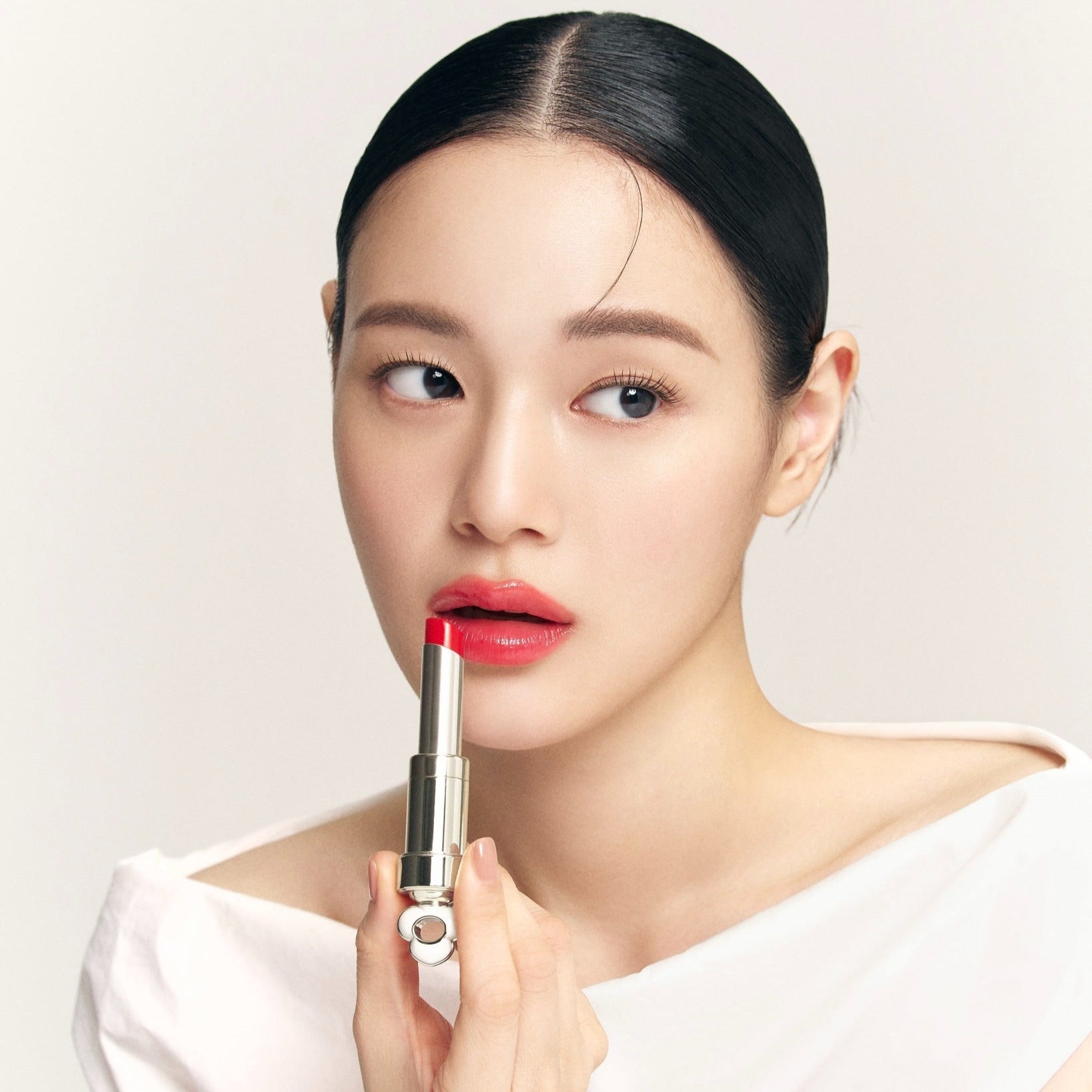THE WHOO Essentail Lip Glow Balm, baume à lèvres de la marque THE WHOO, porté par un modèle maquillé, fond clair.