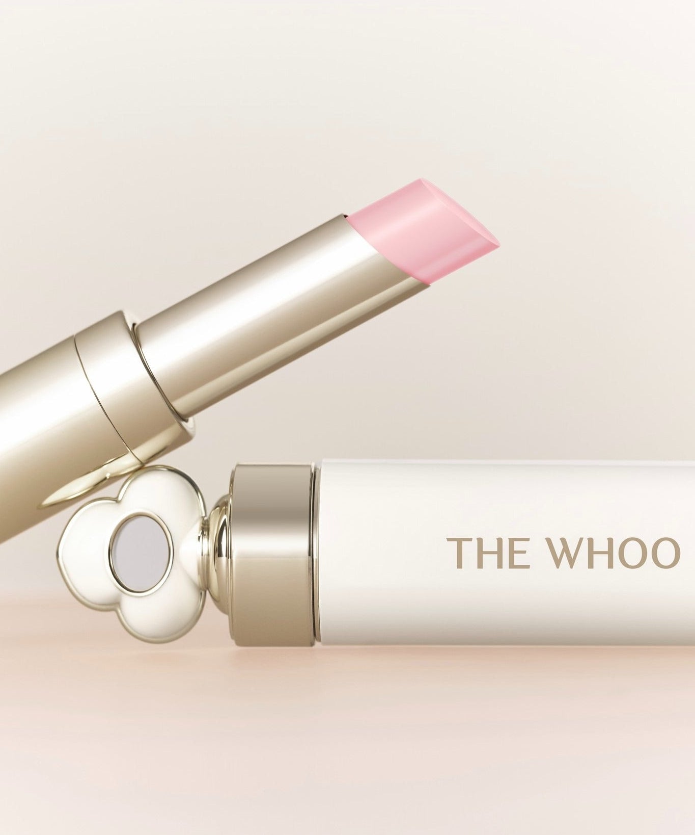 THE WHOO Essentail Lip Glow Balm, baume à lèvres rose sur fond clair, packaging élégant de la marque THE WHOO.