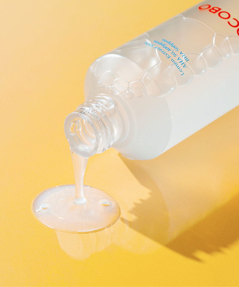 TOCOBO AHA BHA Lemon Toner versement liquide sur une surface jaune brillante, soin de la peau en profondeur avec des ingrédients naturels puissants.