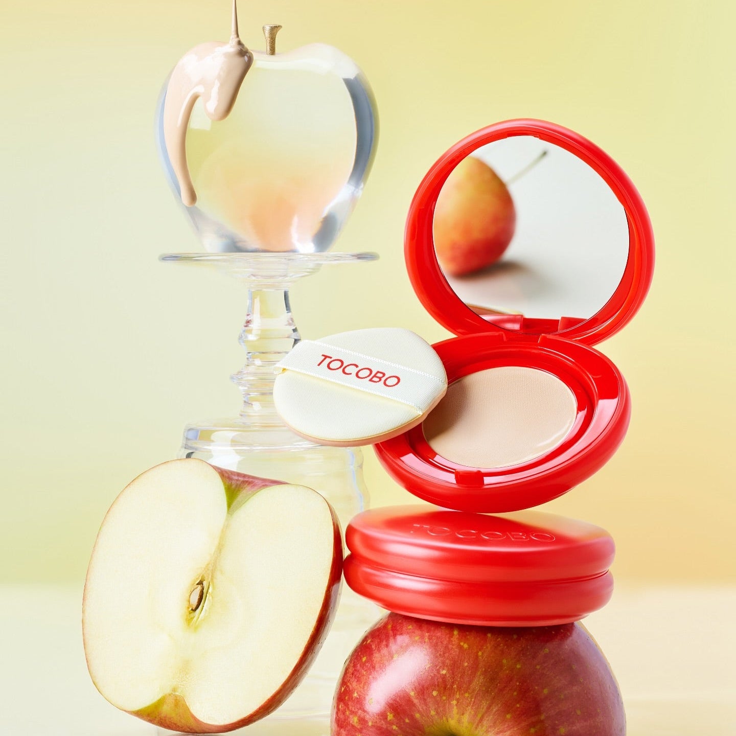 TOCOBO Apple Dewy Fit Cushion, coussin démakeup rose rouge avec pomme et flacon sur fond jaune, produit TOCOBO