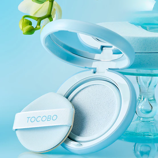 TOCOBO Blur Finish Sun Cushion de TOCOBO, coussin floutant sur décor bleu frais, packaging ouvert et poudre visible.