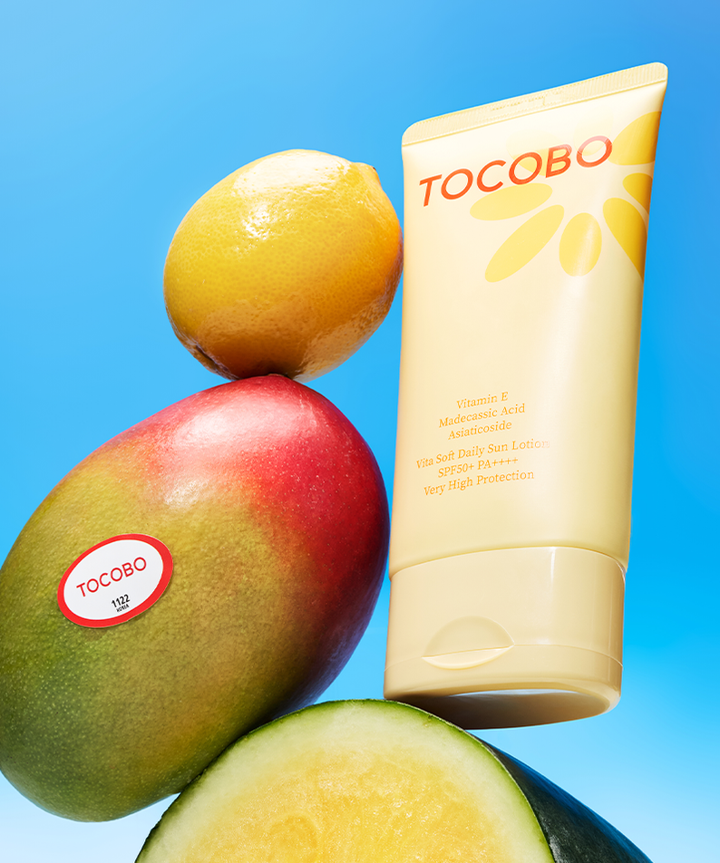 TOCOBO Vita Soft Daily Sun Lotion SPF50+ PA++++ 150ml, tube soleil sur fond bleu avec mangues et fruits.