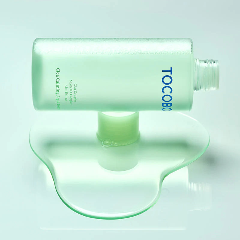 TOCOBO Cica Calming Aqua Toner, flacon vert sur fond turquoise, marque TOCOBO, ambiance soins visage apaisants.