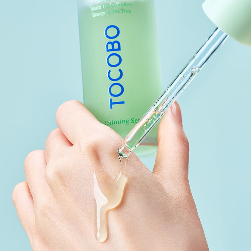 TOCOBO Cica Calming Serum : sérum apaisant TOCOBO sur une main, texture goutte, fond bleu clair