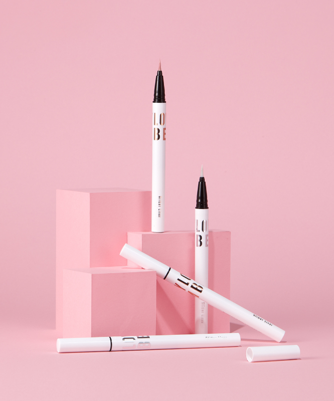 TONY MOLY Aegyo Beam Glitter Liner en scène élégante sur fond rose, design sophistiqué pour maquillage lumineux.