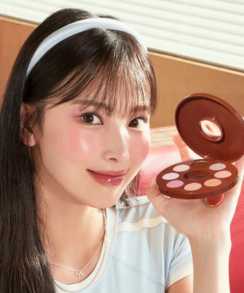 Décris l'image en français: TONY MOLY Eyetone Donut Eyeshadow Palette, marque à découvrir, maquillage yeux sur fond studio.