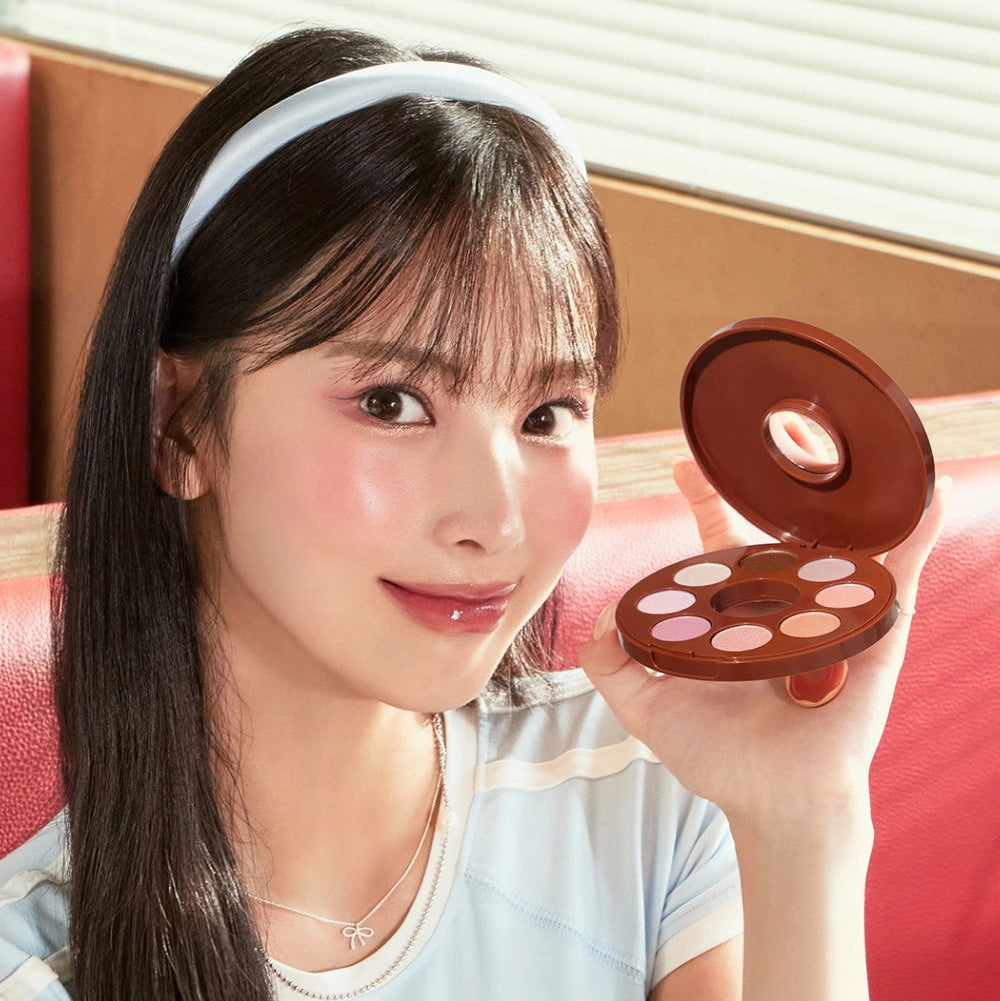 Décris l'image en français: TONY MOLY Eyetone Donut Eyeshadow Palette, marque à découvrir, maquillage yeux sur fond studio.