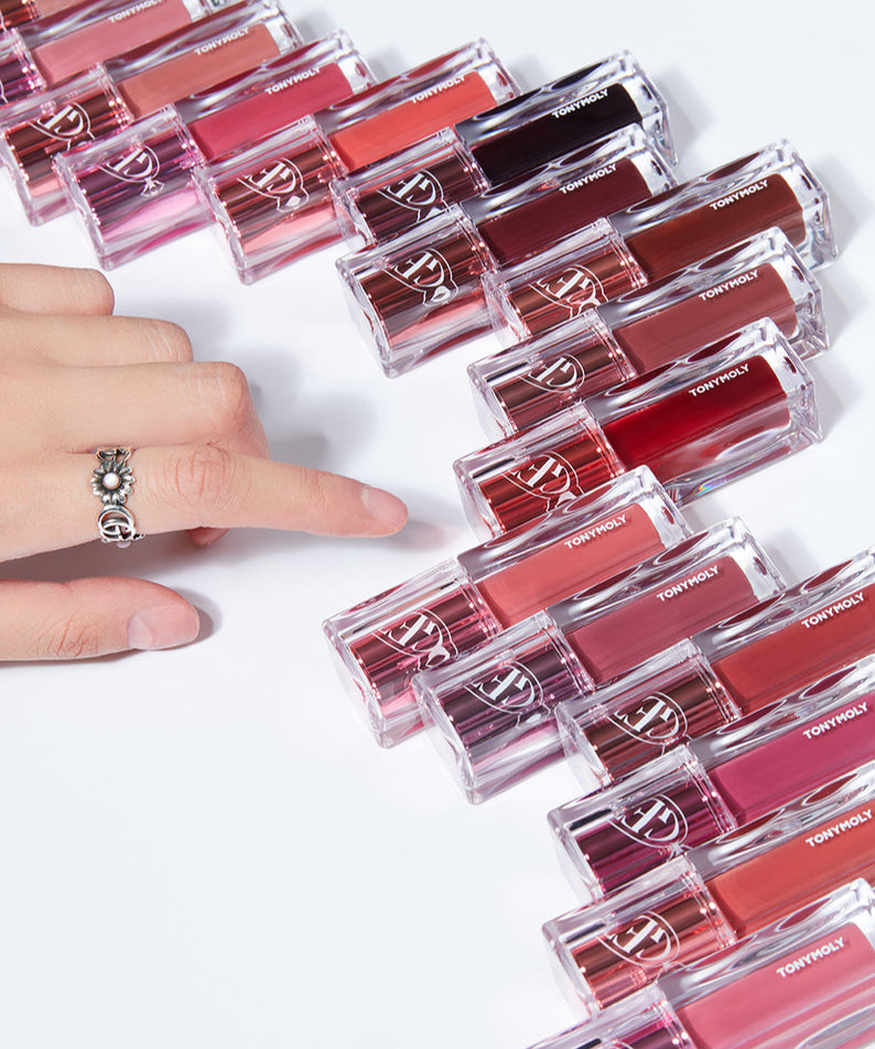 Collection de TONY MOLY Get It Tint Waterful Butter avec doigt pointant vers une teinte, disposition en rangée sur fond blanc.