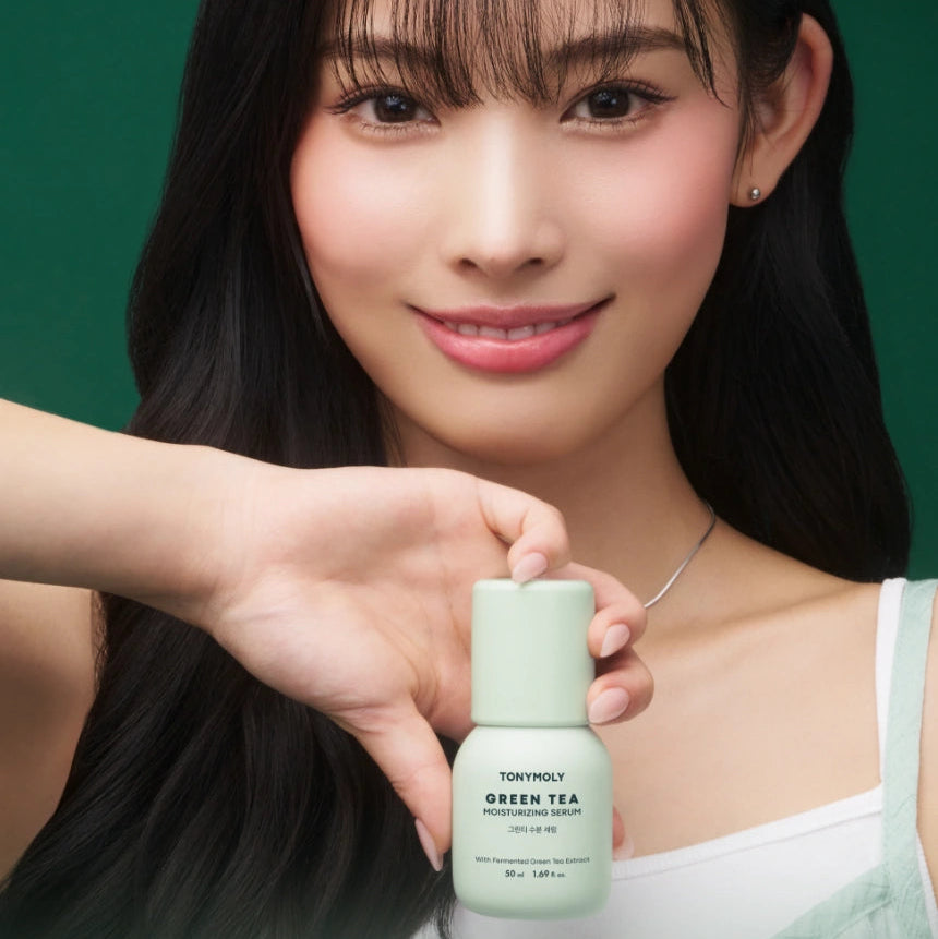 TONY MOLY Green Tea Moisture Serum 50ml, TONY MOLY: sérum photo produit tenu par une femme, fond vert.