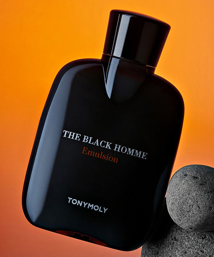 TONYMOLY The Black Homme Emulsion 160ml, flacon noir sur fond orange, avec pierre grise pour contexte visuel.