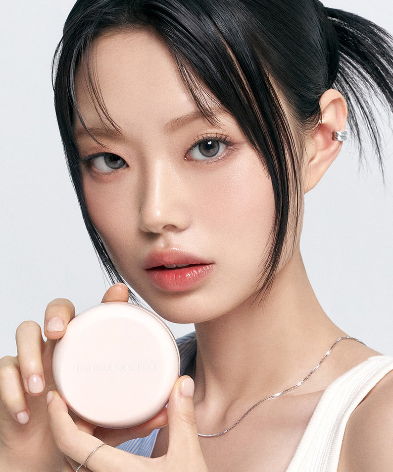 TOO COOL FOR SCHOOL Fixing Dew Cushion [Main Product + Refill], femme tient le boîtier sur fond clair, maquillage hydratant.
