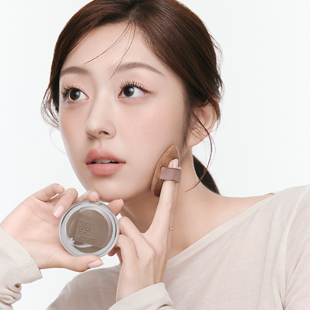 TOO COOL FOR SCHOOL Veiled Contour : maquillage du teint sur visage, poudre compacte tenue par une femme, fond clair
