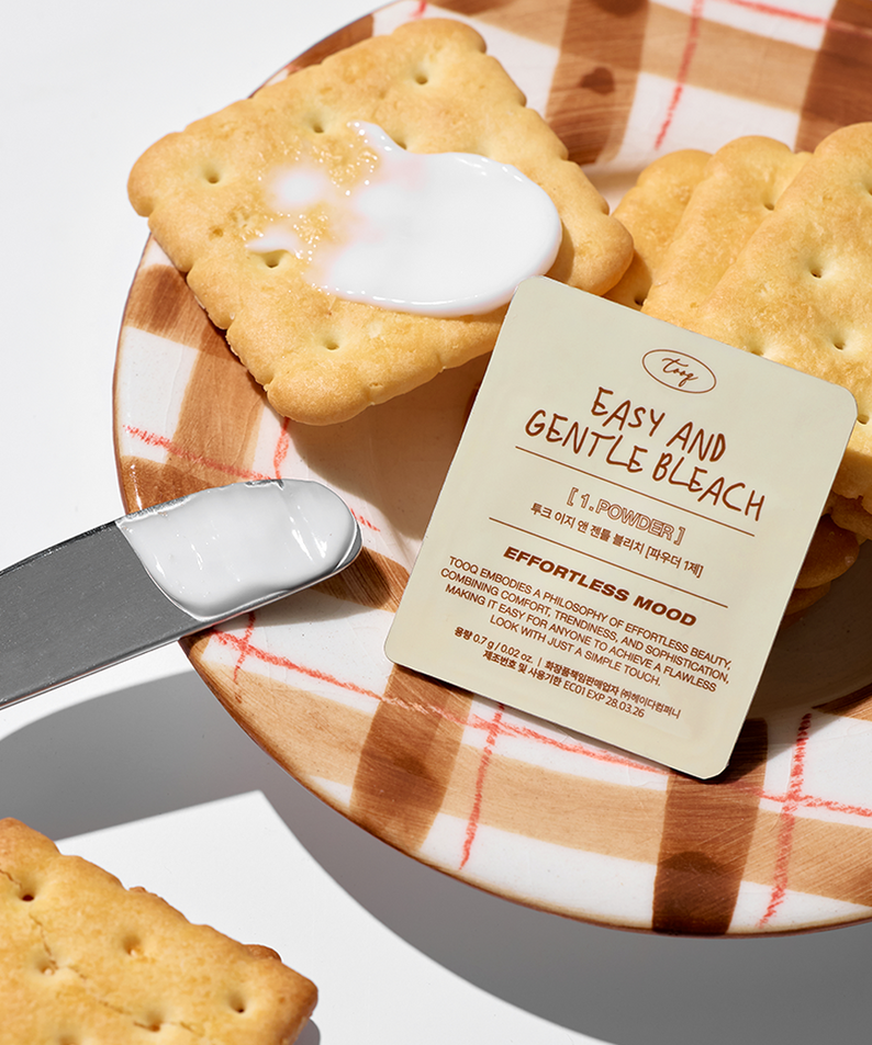TOOQ Easy And Gentle Bleach de la marque TOOQ, sur plateau en bois avec biscuits et glaçage blanc, contexte pâtisserie