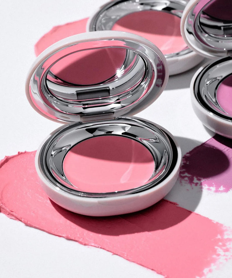 TOOQ Satin Peach Blossom : maquillage rose avec boîtiers métalliques, reflets et éclaboussures sur fond clair.