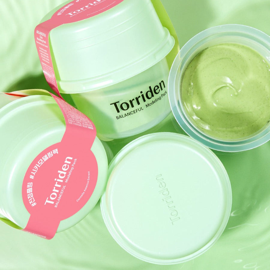 Décris l’image en français: TORRIDEN Balanceful Cica Modeling Pack 30g de la marque Torriden sur fond vert, pots ouverts.