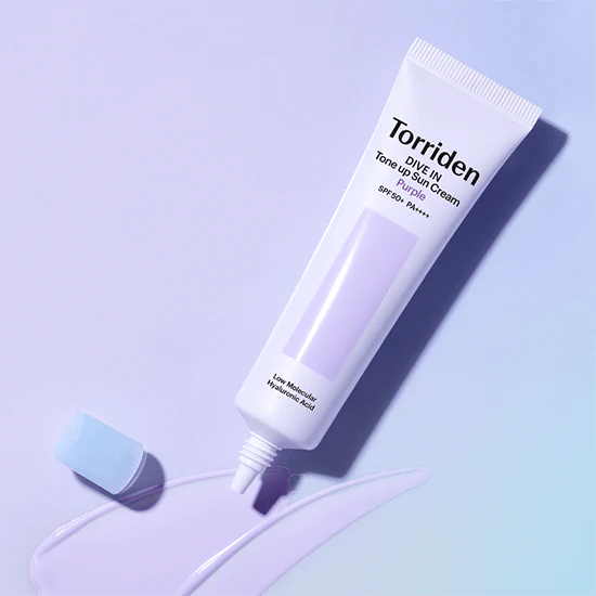 TORRIDEN Dive In Tone Up Sun Cream Purple 50+PA++++ 60ml, crème solaire violette de la marque Torriden sur fond bleu clair.